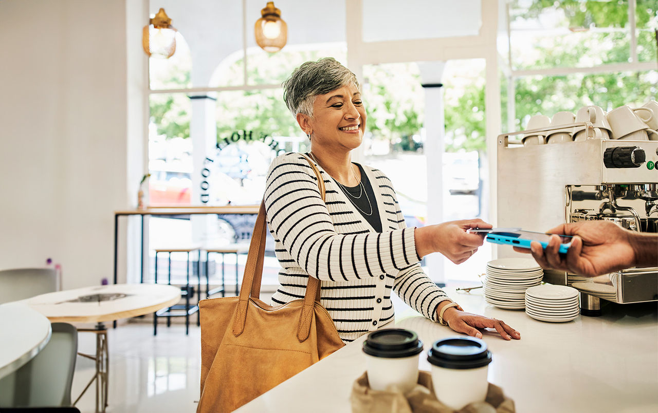 Woman paying with her credit card at a coffee shop