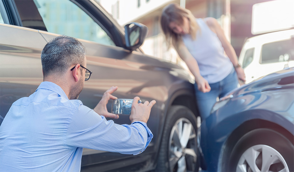 Man photographing damage after a vehicle collision
