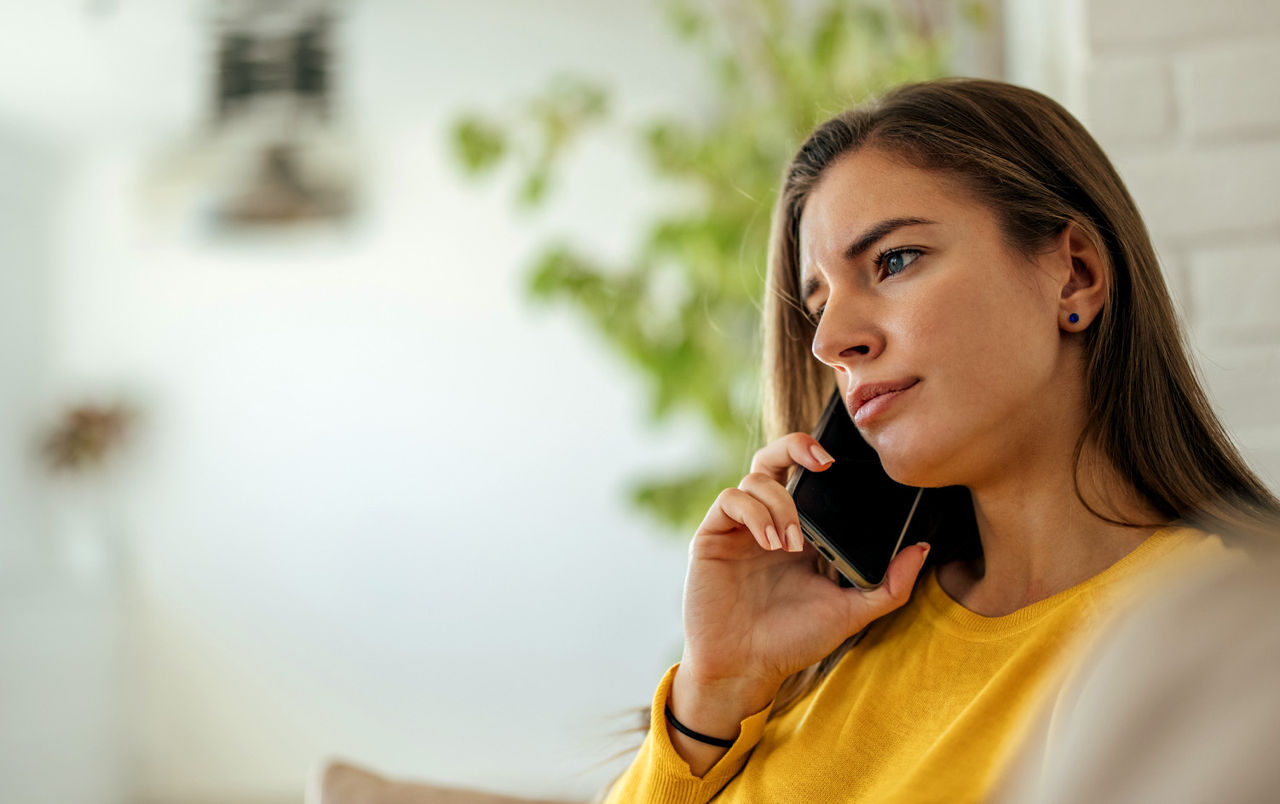Woman sitting on a couch while talking on her phone