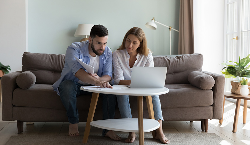 Man and woman sitting with a laptop and tax forms